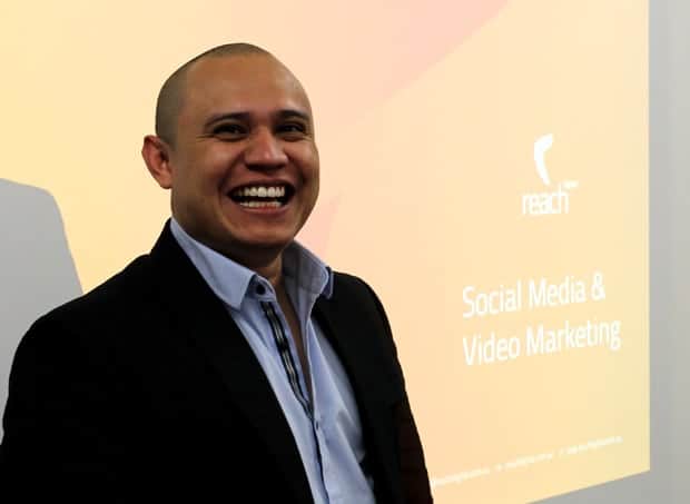 Reach Digital presenter smiling beside a Social Media and Video Marketing presentation slide